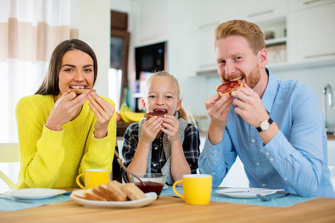 Smiling family eating bread and jam